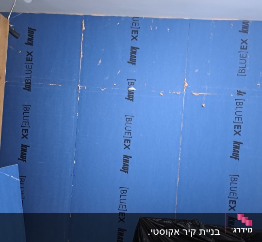 קיר גבס כחול עם לוגו קנאוף